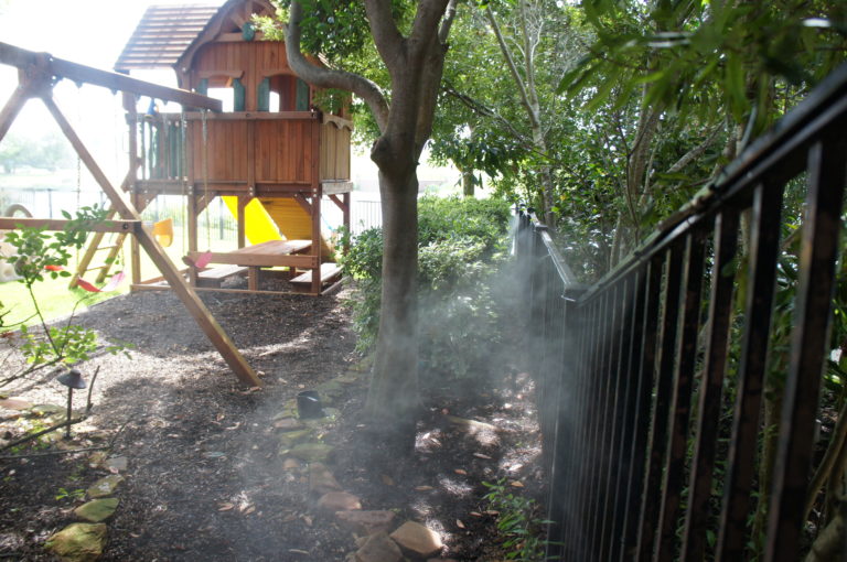 backyard with mosquito misting system spraying fence